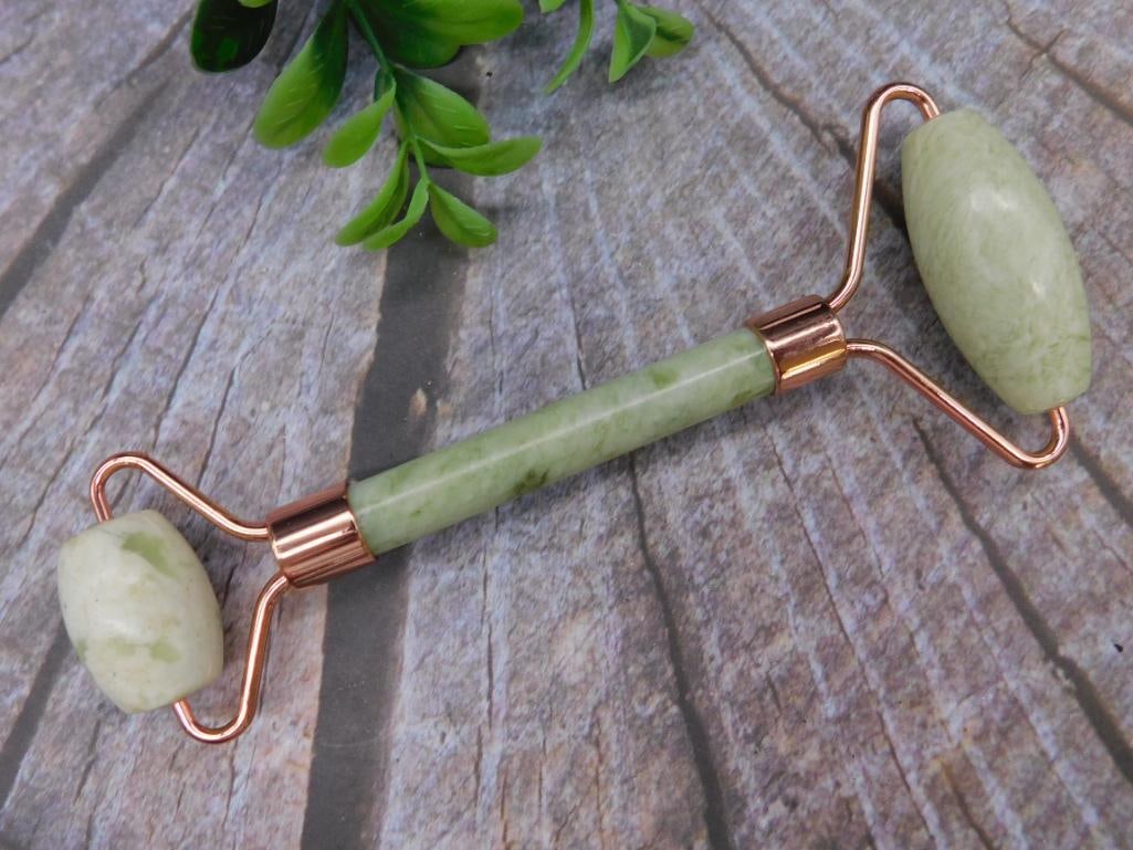 Jade Facial Roller with Rose-Tone Metal Accents: Dual-sided roller designed with green stone and rose-tone metal handles. Ideal for skincare routines with two different-sized roller heads for versatile use. Portable and stylish, it combines aestheti