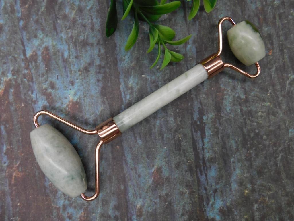 Dual-Ended Jade Facial Roller with Copper Accents: This listing is for a dual-ended jade facial roller designed for skincare application. The roller features polished jade rollers on both ends, securely attached to a copper frame. It includes one larg