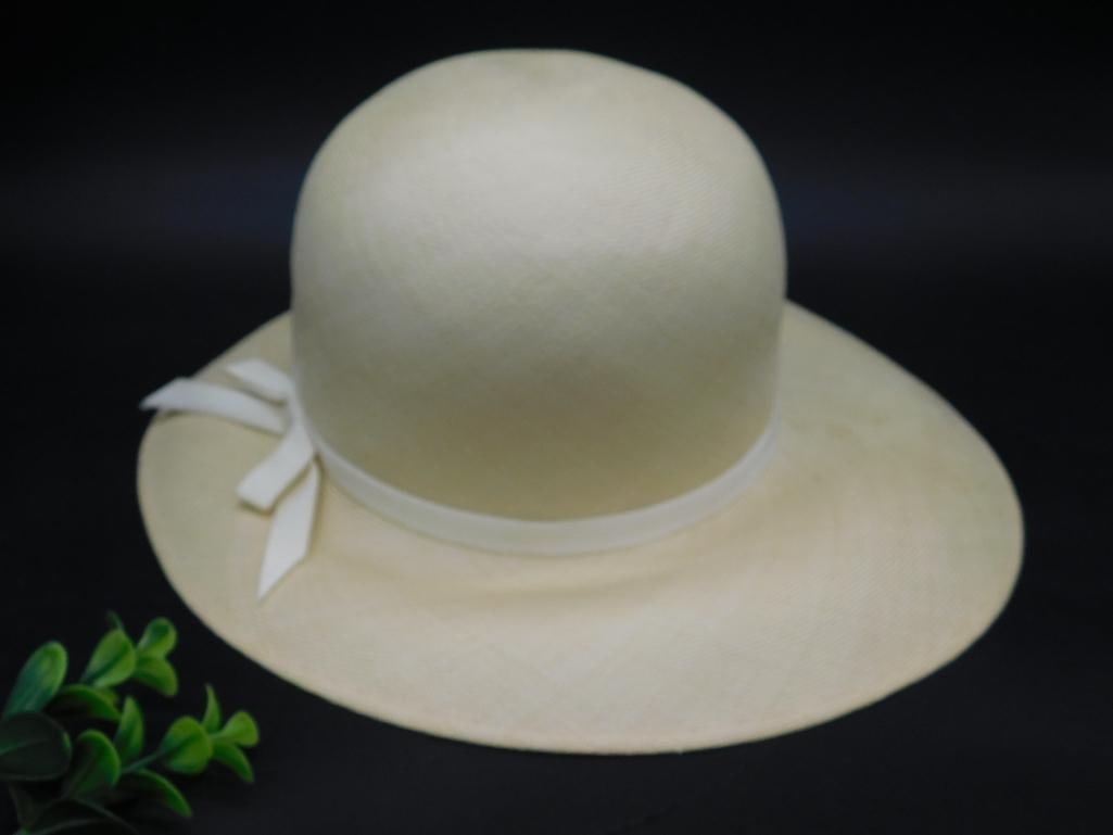 Frank Olive for Montaldo's Straw Hat with Ribbon Accent: - Straw hat designed by Frank Olive for Montaldo's. | - Light cream-colored material with a wide brim. | - Features a stylish ribbon trim and bow detail on the side. | - Interior labeled with 'Frank O