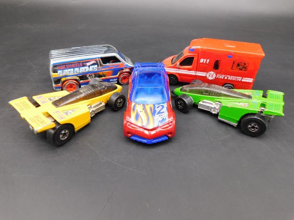 Assorted Die-Cast Toy Cars and Van Collection: This lot includes a colorful assortment of die-cast vehicles including two race cars, a fire and rescue van, a custom van, and another race vehicle. Brands identified include Mattel Hot Wheels and Mai