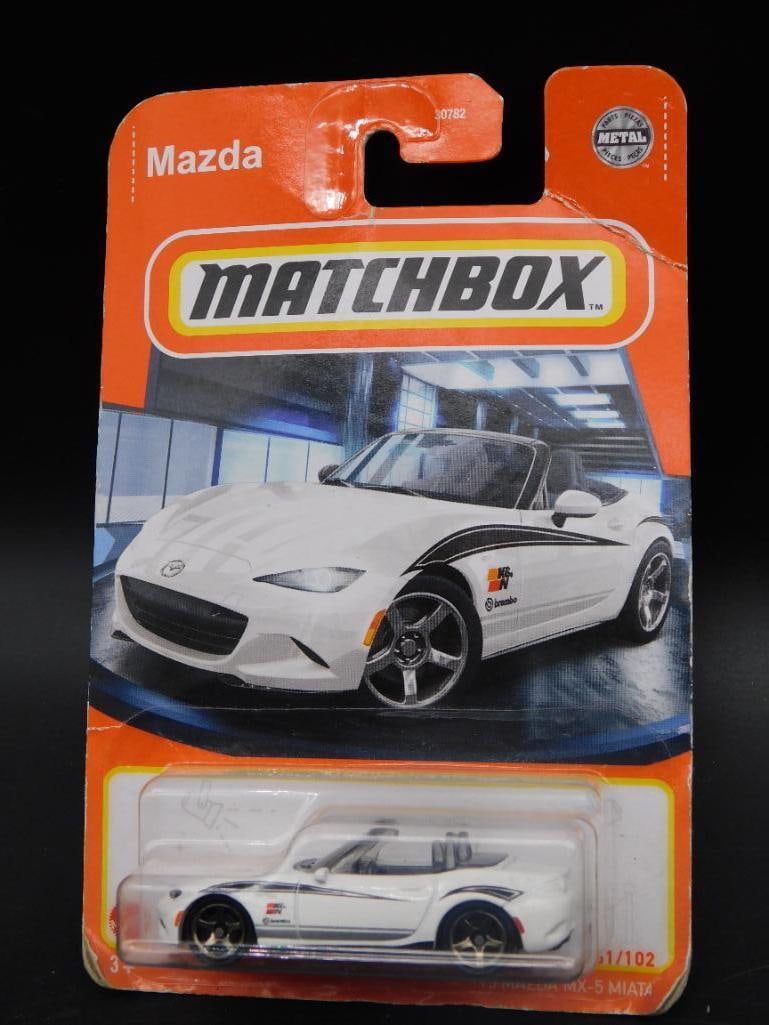 Matchbox 15 Mazda MX-5 Miata Die-Cast Car in Original Packaging: - Matchbox die-cast model car featuring the '15 Mazda MX-5 Miata. | - Packaging indicates the car is model 61 out of 102 in its series. | - Original sealed packaging with a clear blister displaying th
