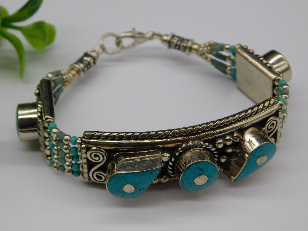 Turquoise and Silver-Toned Bracelet with Intricate Details: - Bracelet features turquoise accents and silver-toned details. | - Intricate craftsmanship with decorative patterns. | - Adjustable clasp closure for a custom fit. | - Dimensions clearly visible in t