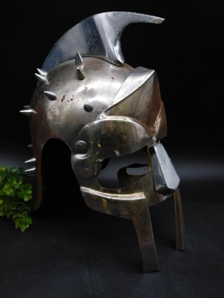 Spiked Metal Spartan-Style Helmet with Crest: Made of metal with a silver-tone finish. | Features a prominent spiked design across the top and sides. | Includes a crest-like element extending from the top. | Helmet shows signs of wear, including