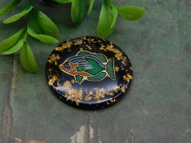 Round Resin Disc Featuring a Fish Design and Gold Details