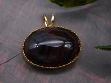 Gold-Tone Pendant With Dark Oval Gemstone