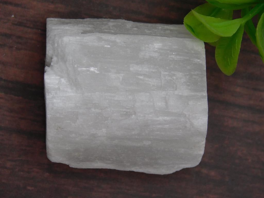 SELENITE ROCK STONE LAPIDARY SPECIMEN: SELENITE mineral specimen with natural coloration and texture. | - Weighs 38 grams as noted on accompanying label. | - Item is displayed alongside a US quarter for size reference (quarter not