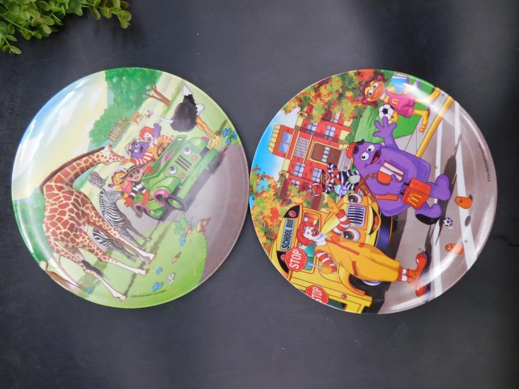 2004 McDonald?s Collectible Character Plates (Set of 2): Set of 2 collectible plates released by McDonald's in 2004. | Each plate showcases vibrant designs with animal and character-themed illustrations. | Both plates are branded with "2004 McDonald's