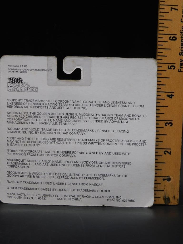 Racing Champions Collectible Car: Rectangular packaging featuring printed text on the back with a central hook attachment for hanging. It includes details possibly related to a toy, with measurements shown near the top edge. Sold as