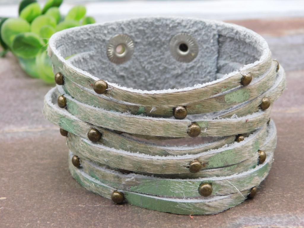 COW HIDE STUDDED CUFF BRACELET: COW HIDE STUDDED CUFF BRACELET - Part of our Discover Golden Attic, Crystals and Gems auction at HATMAN'S Auctions! Please see photos for measurements and condition. YES, we have in-house shipping!