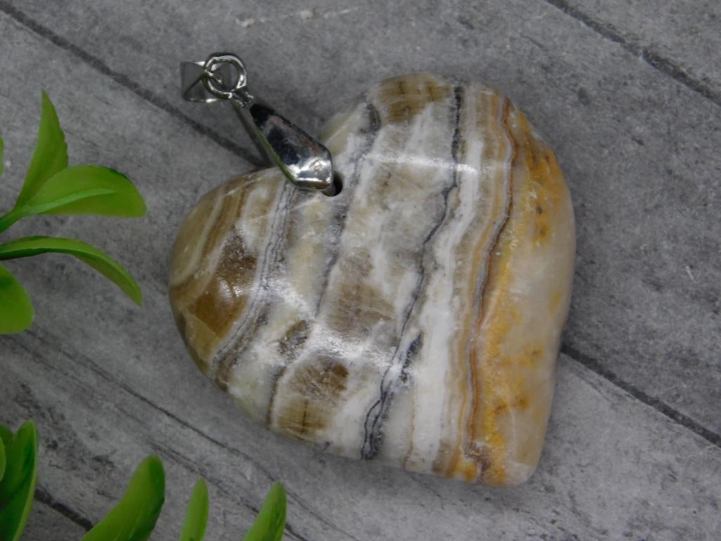 BANDED CALCITE HEART PENDANT ROCK STONE LAPIDARY SPECIMEN: BANDED CALCITE HEART PENDANT ROCK STONE LAPIDARY SPECIMEN — Part of our Discover Vintage Vault, Crystals and Gems auction at HATMAN'S Auctions! Please see photos for measurements and condition. YES,