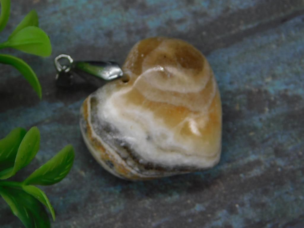 BANDED CALCITE HEART PENDANT ROCK STONE LAPIDARY SPECIMEN: BANDED CALCITE HEART PENDANT ROCK STONE LAPIDARY SPECIMEN — Part of our Discover Vintage Vault, Crystals and Gems auction at HATMAN'S Auctions! Please see photos for measurements and condition.