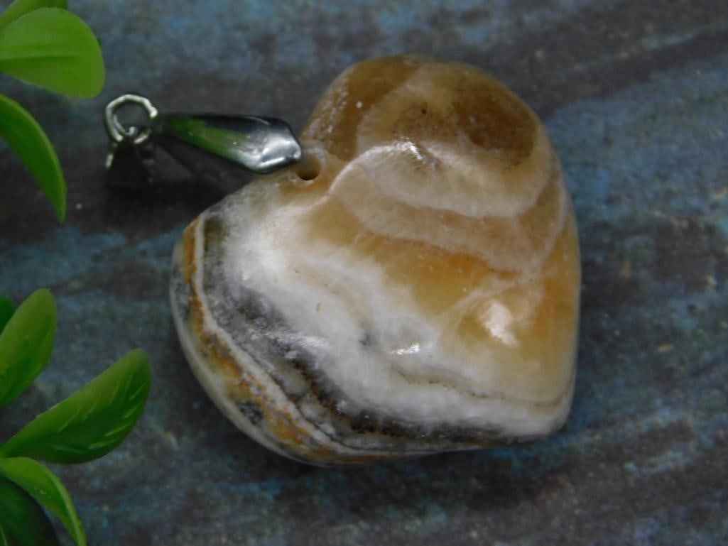 BANDED CALCITE HEART PENDANT ROCK STONE LAPIDARY SPECIMEN: BANDED CALCITE HEART PENDANT ROCK STONE LAPIDARY SPECIMEN — Part of our Discover Vintage Vault, Crystals and Gems auction at HATMAN'S Auctions! Please see photos for measurements and condition. YES,