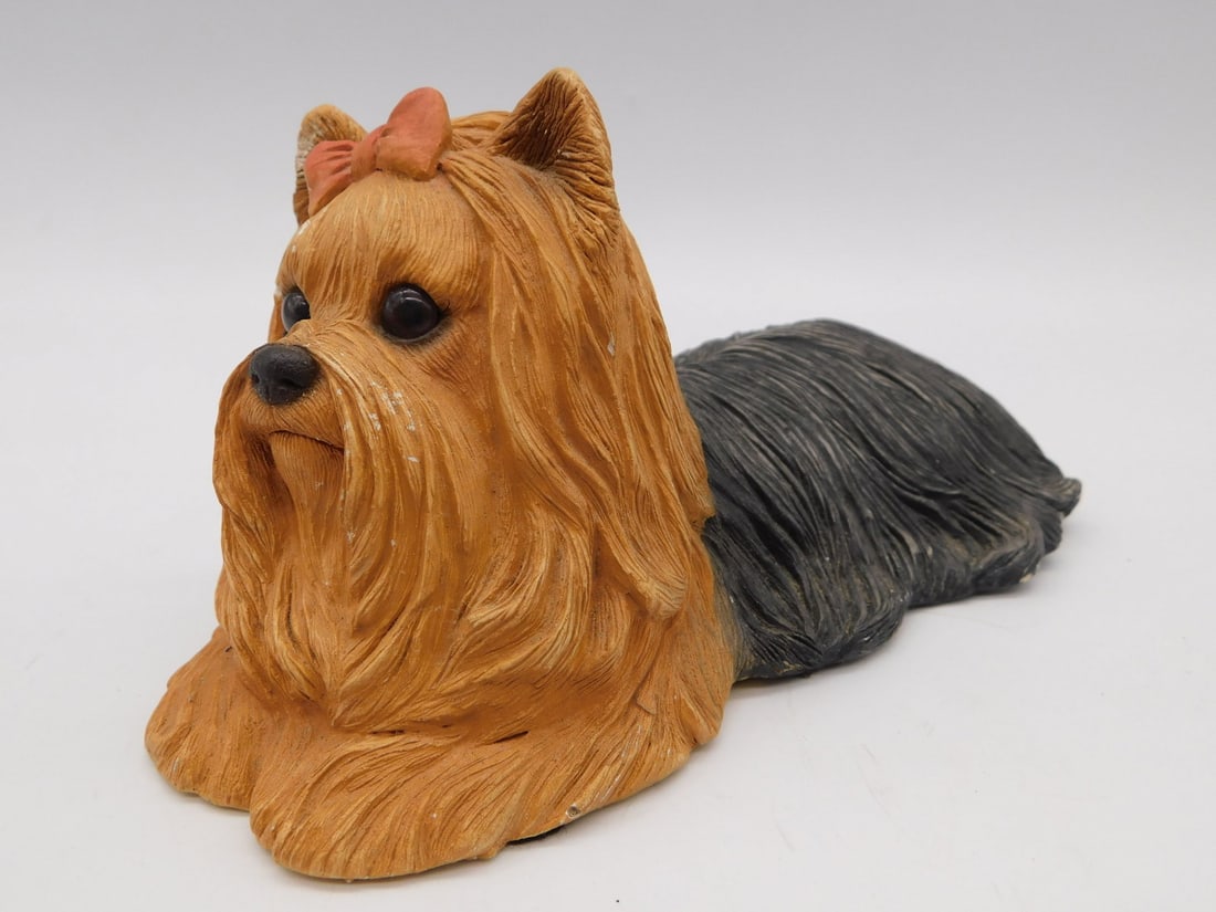 Yorkshire Terrier Dog Figurine - Signed Resin Sculpture with Bow: This detailed resin figurine depicts a Yorkshire Terrier lying down, with a textured coat finished in tan and black tones and a small bow accent on the head. The underside bears a handwritten artist s