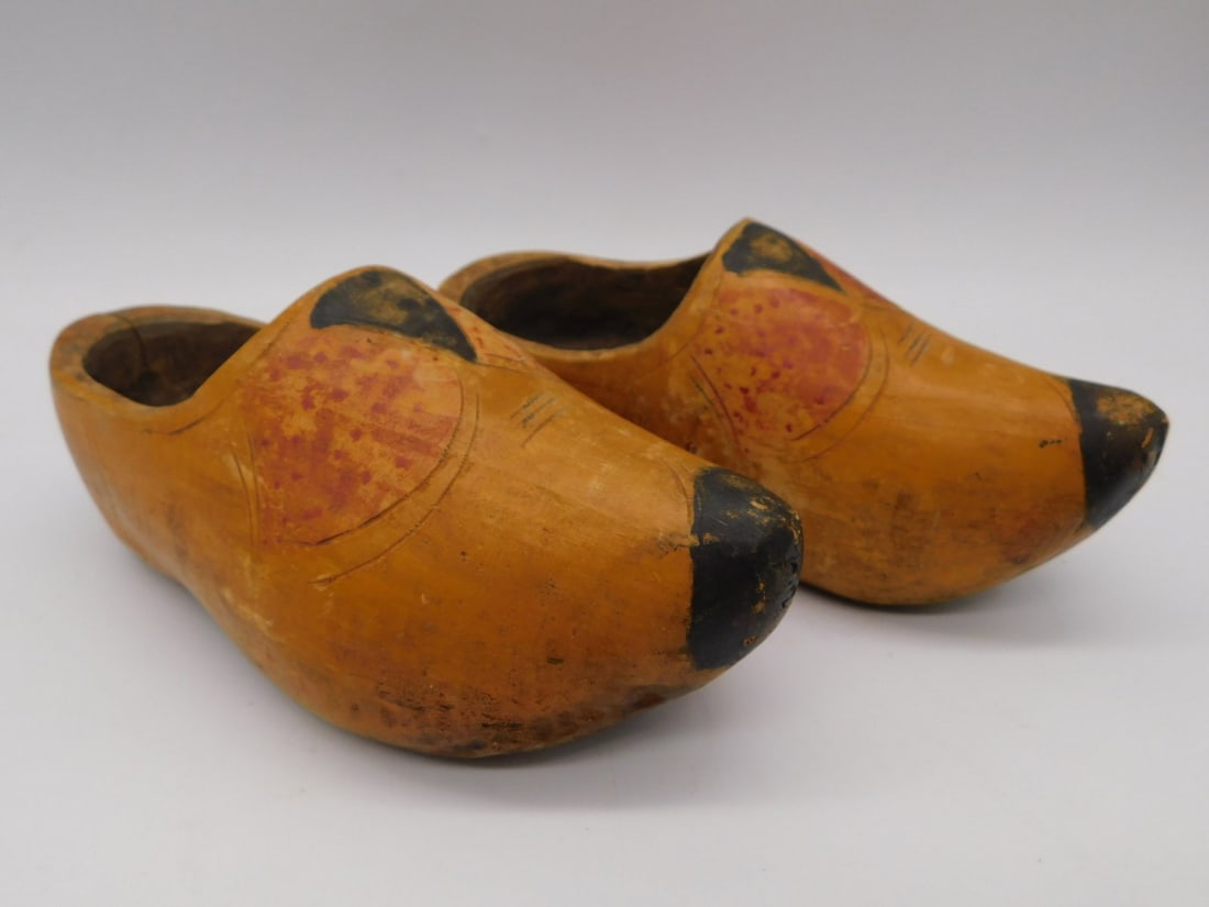Antique Hand-Painted Wooden Dutch Shoes / Clogs Pair: This pair of antique wooden Dutch-style shoes (clogs) is hand-carved from a single block of wood with black-painted toe and heel caps. Each shoe is decorated with a hand-painted floral motif in orange