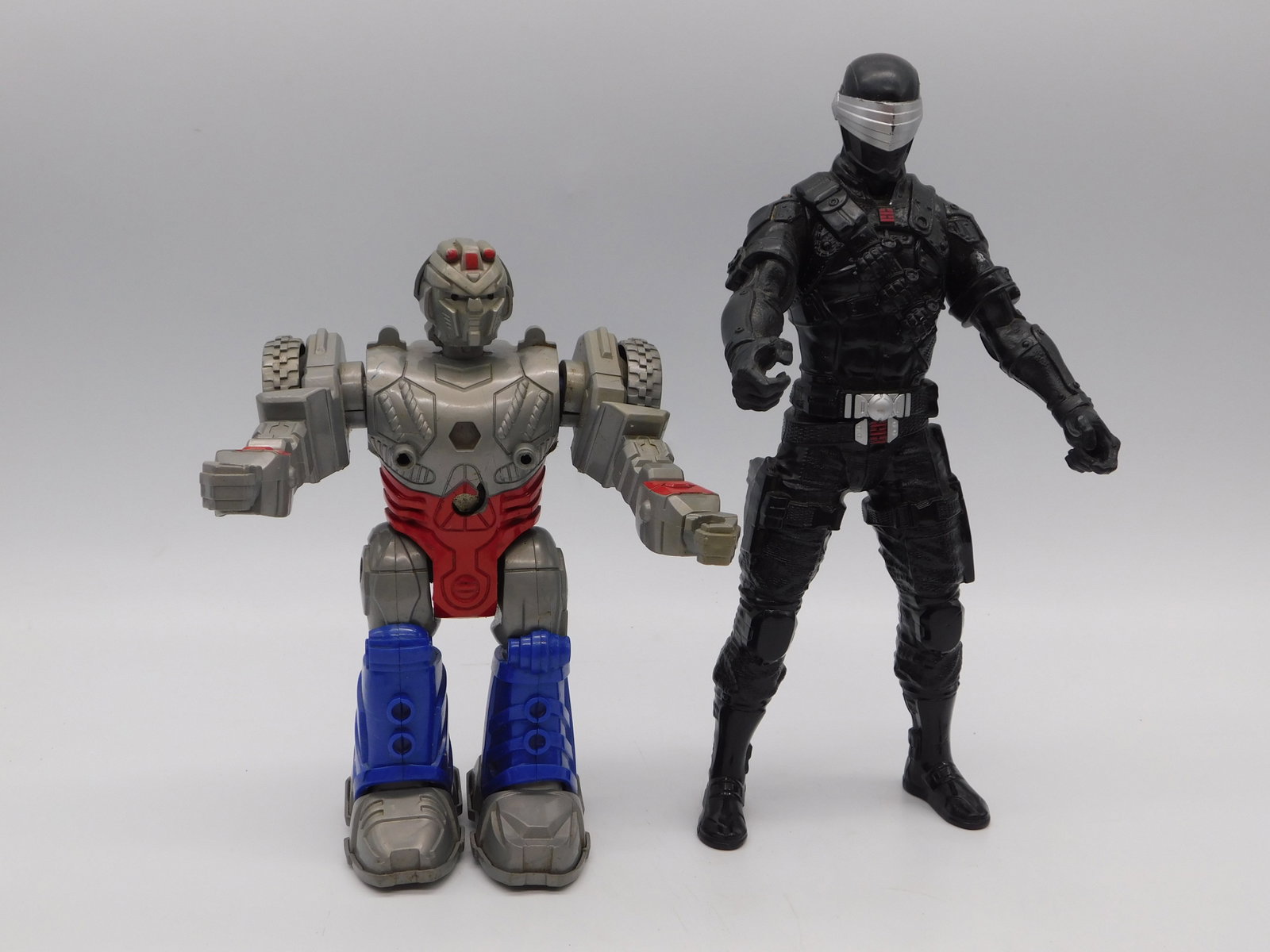Modern Action Figure Pair Robot Tactical Soldier Collectible Lot: Modern Action Figure Pair Robot Tactical Soldier Collectible Lot featuring two highly detailed articulated action figures. The first figure is a sophisticated gray, tan, and blue mech-style robot with