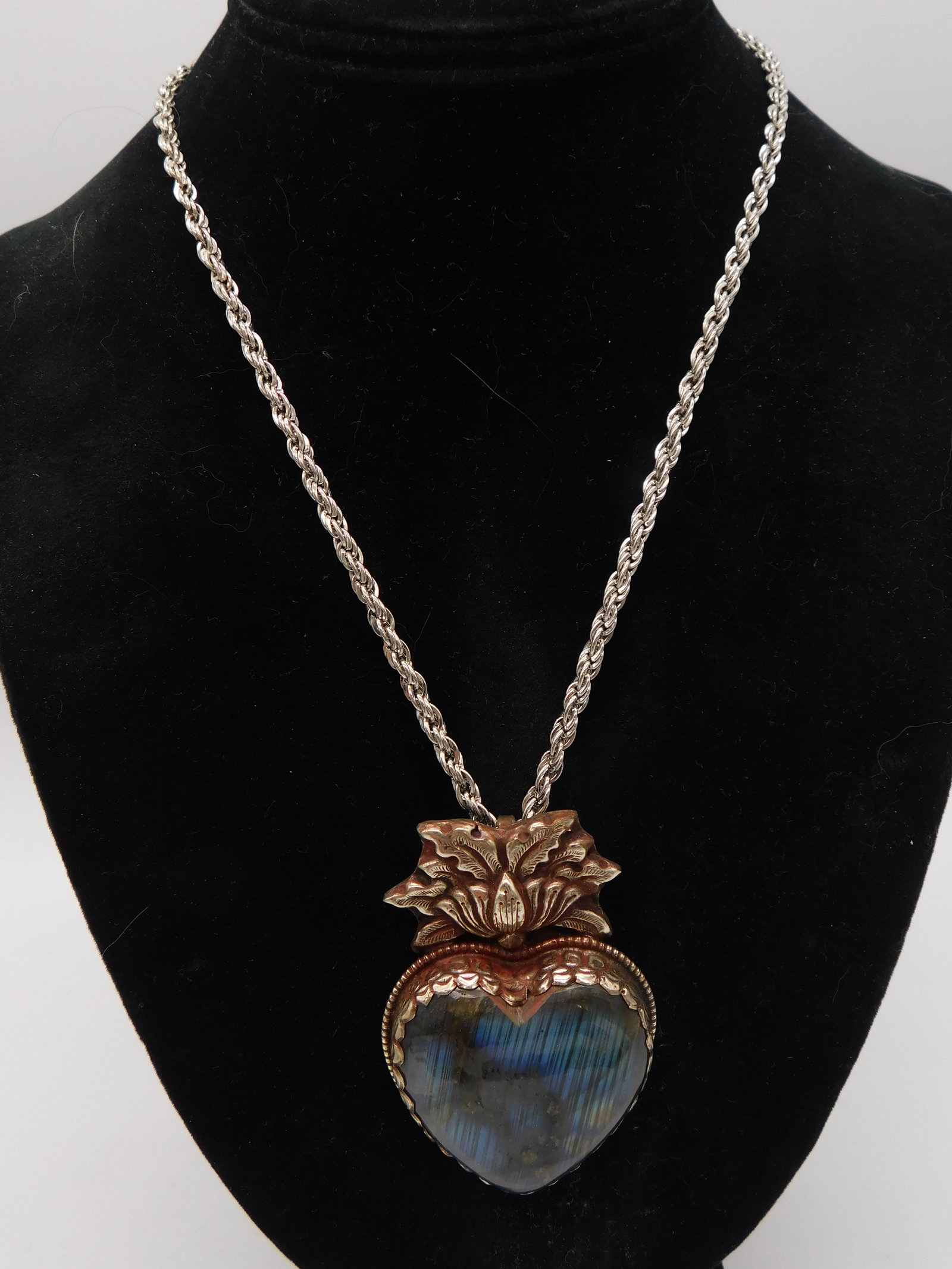 Necklace — Labradorite Gemstone Pendant Necklace with Copper Lotus Setting Silver Rope Chain: A large labradorite cabochon pendant displaying vivid blue and teal flash labradorescence set in a copper-tone embossed lotus flower bezel. The pendant is approximately 1.5 inches tall. Suspended on