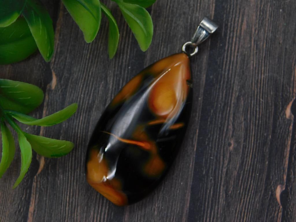 Amber and Black Agate Teardrop Pendant - Stone Jewelry Pendant: A polished teardrop pendant in swirling amber, black, and orange tones with a simple silver-tone bail. The pendant measures approximately 2 inches long. A bold statement piece for any stone jewelry co