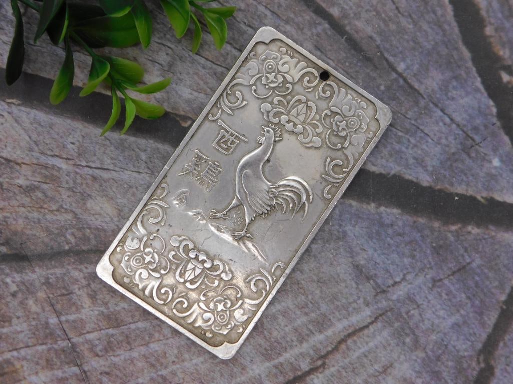 Silver Rooster Plaque - Chinese Zodiac Jewelry Pendant: A rectangular silver-tone metal plaque Featuring an embossed rooster design surrounded by floral scrollwork and Chinese characters, with a drilled hole for hanging. The pendant measures approximately