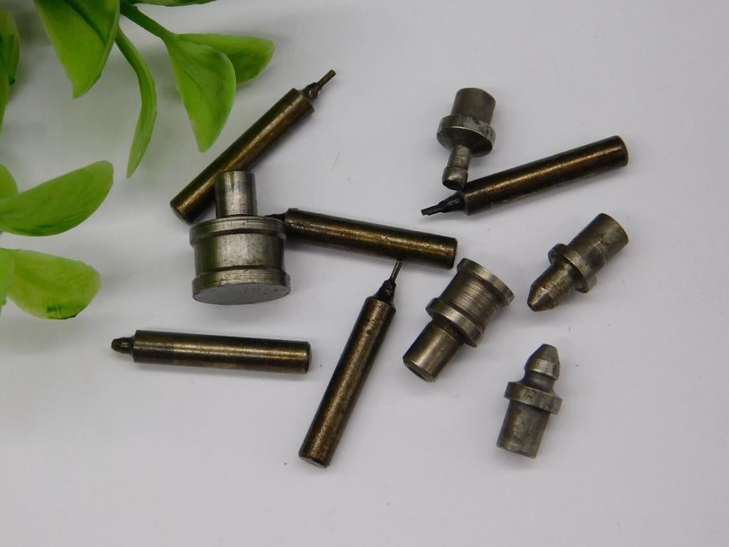 Small Metal Punch or Stamp Tools: Includes a set of metal punch or stamp tools, 9 pieces in total. | Varied designs and shapes; likely used for creating impressions on materials. | Made of durable metal, showing a vintage patina. |
