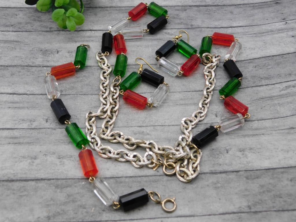 Multicolor Glass Bead Necklace and Earring Set: A festive necklace and matching pierced earring set featuring red, green, black, and clear faceted glass beads joined by a silver-tone chain. The bold color combination gives this costume set real