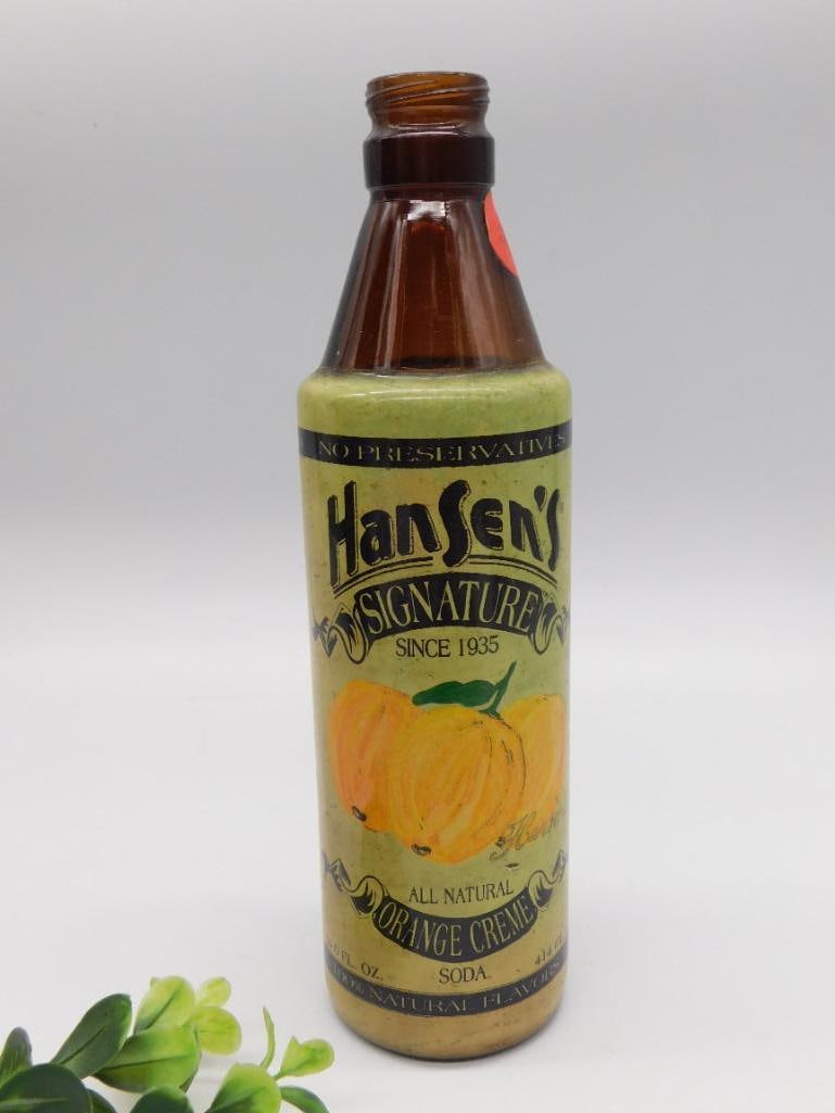 Vintage Hansen's Signature Orange Creme Soda Bottle: An amber glass soda bottle with a colorful paper label for Hansen's Signature Orange Creme soda, noting 'Since 1935.' Stands approximately 9 inches tall. A nice piece for vintage advertising and