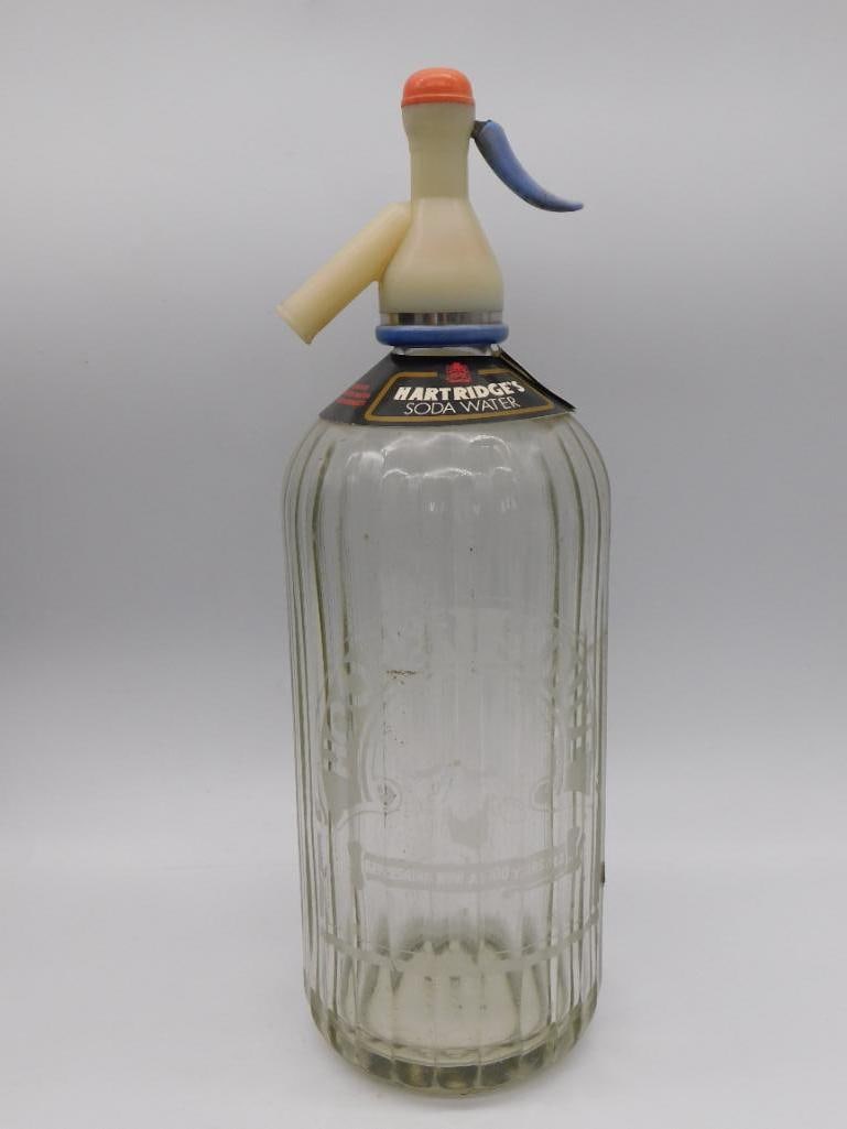 Hartridge's Soda Water Glass Syphon Bottle - Antique Seltzer Bottle: A vintage glass soda syphon bottle etched "Hartridge's Soda Water," complete with its original dispensing head. The bottle stands approximately 12 inches tall. A great decorative piece for kitchen or