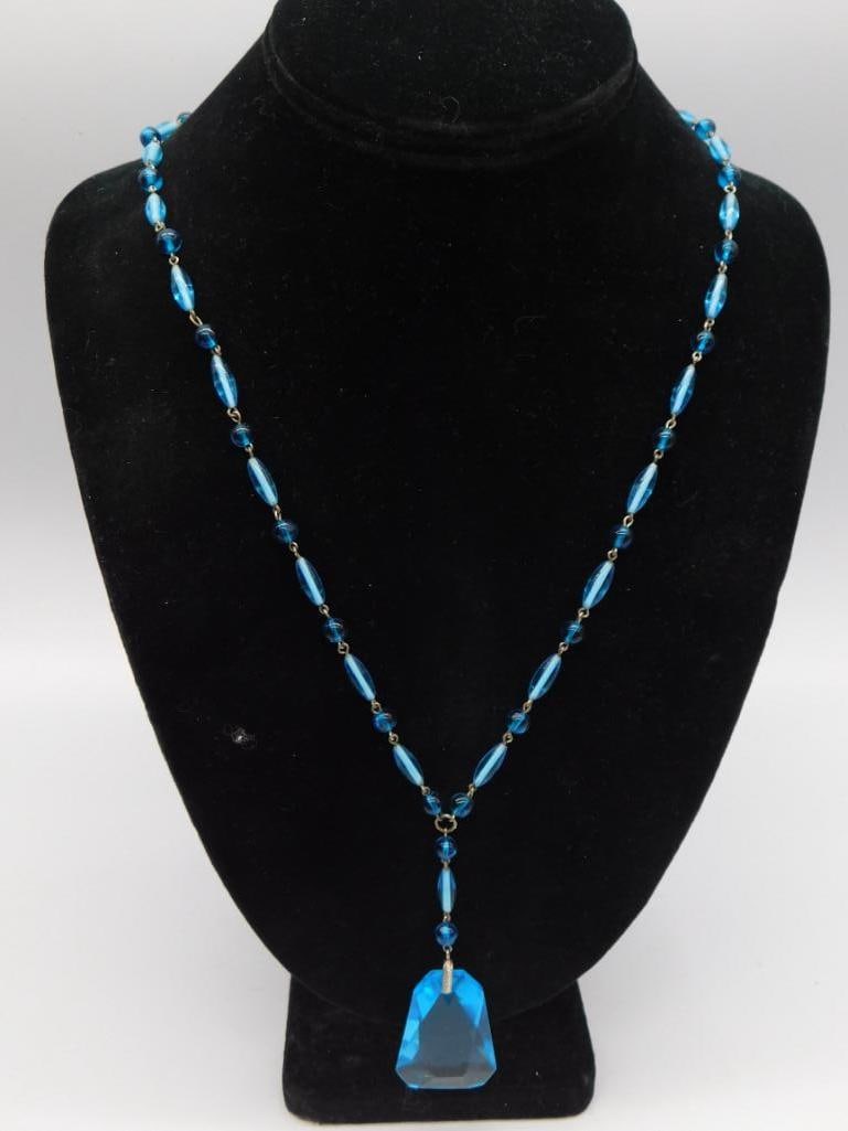 Blue Faceted Glass Pendant Necklace - Beaded Drop Necklace: A beaded necklace strung with blue glass ovals and rounds, finished with a large faceted blue glass drop pendant. The necklace measures approximately 17 inches long, not including the drop. A striking