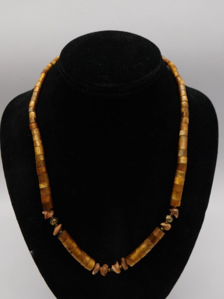 Wood and Shell Chip Bead Necklace: A necklace strung with golden wood disc beads accented by natural shell chip beads and small metallic spacer beads. Measures approximately 20 inches in length. An easy-to-wear necklace with natural