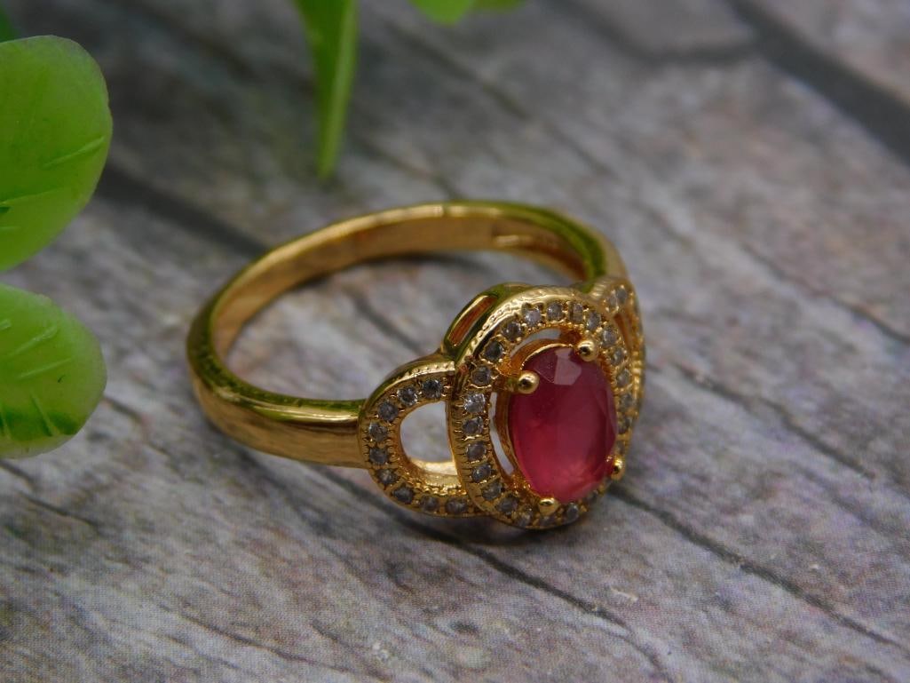 Gold-Tone Ring with Pink Stone Halo, Size 7: A gold-tone ring featuring a pink oval center stone surrounded by a double halo of small sparkling accent stones, size 7. A pretty, eye-catching ring for everyday wear.