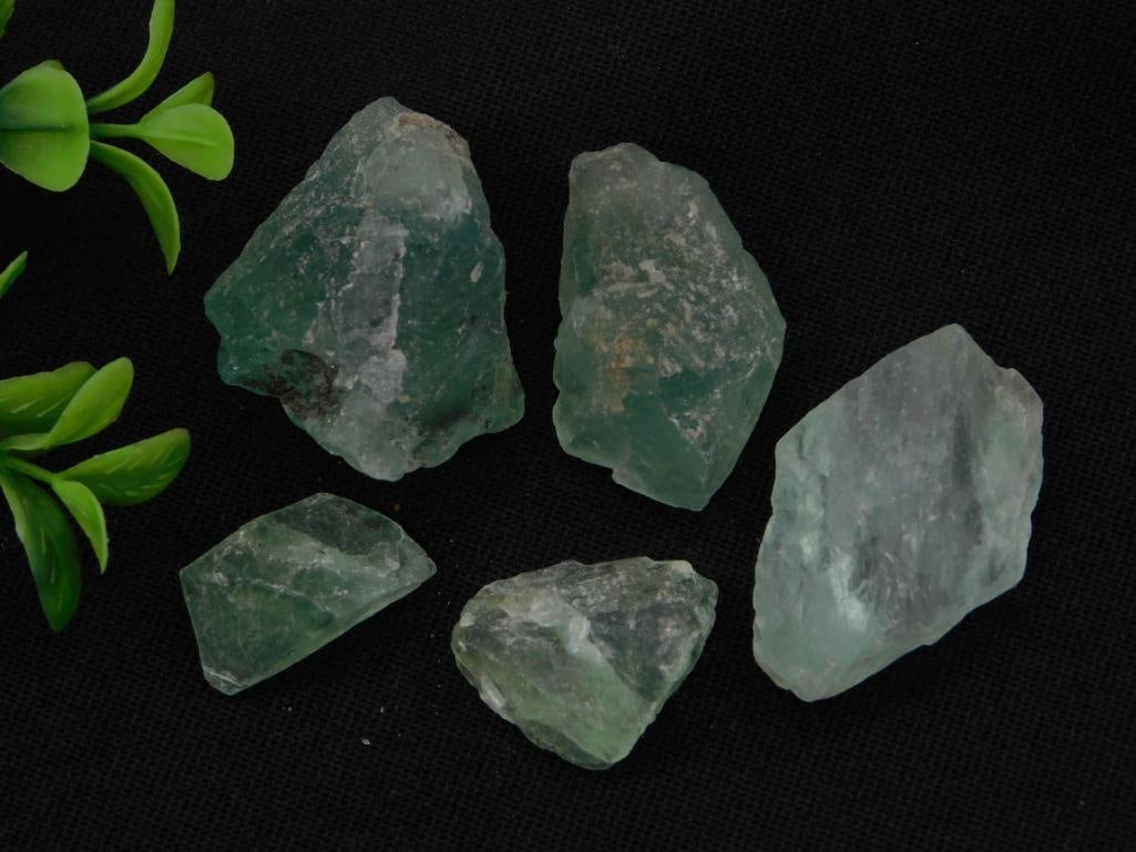 Natural Green Fluorite Rough Specimens, Lot of 5: Five rough, unpolished green fluorite crystal chunks with translucent, glassy faces. Auction tag lists combined weight at 94 grams. Pieces range from about 1 to 2.5 inches, shown with a quarter for