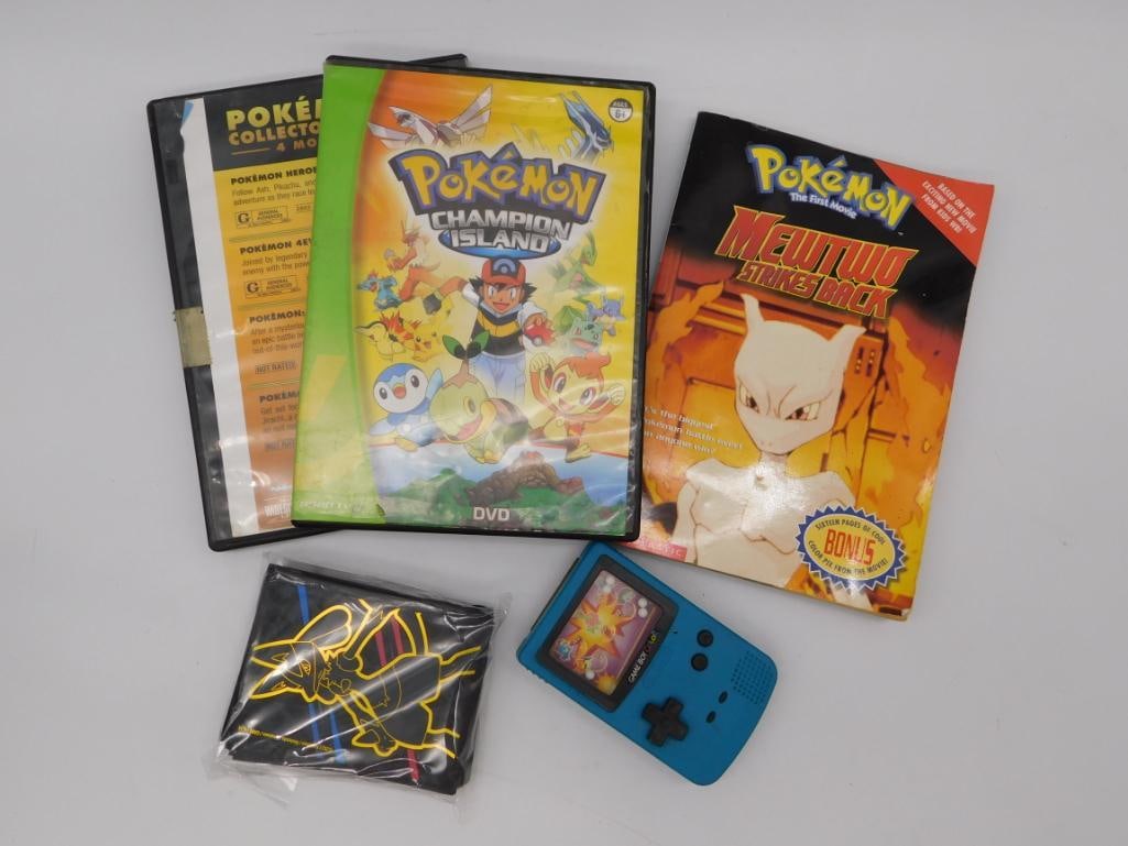 Pokemon DVD, Book & Handheld Game Collector Lot: Mixed Pokemon media lot including the "Champion Island" DVD, a Pokemon Heroes 4-Movie Collector's set DVD, the "Mewtwo Strikes Back" bonus-page storybook, a blue handheld electronic game unit styled