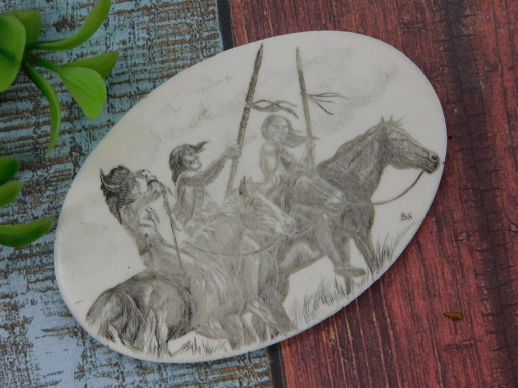 Scrimshaw Style Pendant, Native American Horseback Scene: Oval scrimshaw-style pendant/plaque etched with a detailed scene of Native American riders on horseback carrying feathered lances. Signed 'BA' in the lower corner; carved on ivory-colored bone or resi