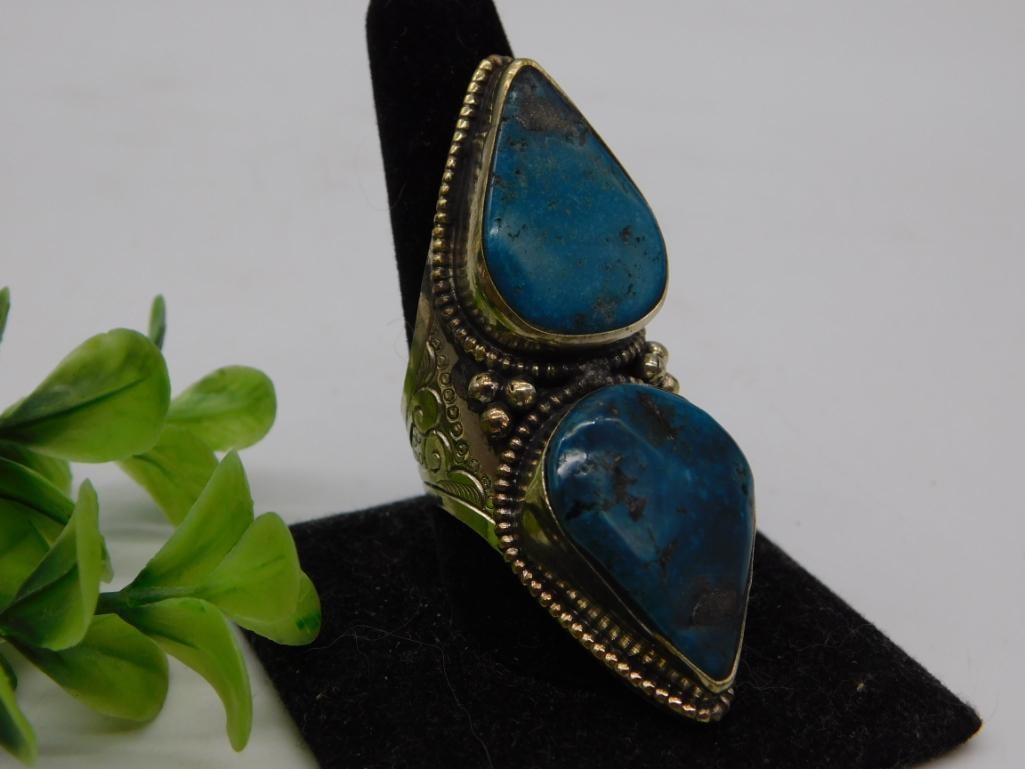 Sterling Silver Double Turquoise Statement Ring: Ornate sterling silver ring set with two large teardrop-shaped natural turquoise cabochons, featuring hand-engraved floral scrollwork and beaded wire detailing on the band. Substantial statement-size