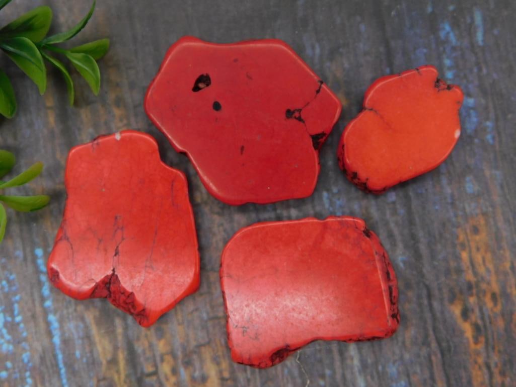 Red Jasper Stone Slabs: Four flat polished slabs of vivid red jasper with dark veining, irregular natural edges. Largest piece approximately 3 inches across.