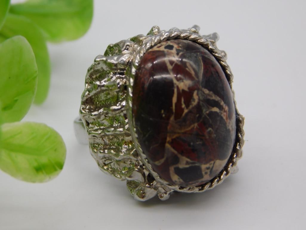 Statement Jasper Cocktail Ring: A large silver-tone textured cocktail ring set with an oval red and cream jasper/agate cabochon stone. Adjustable-style band.