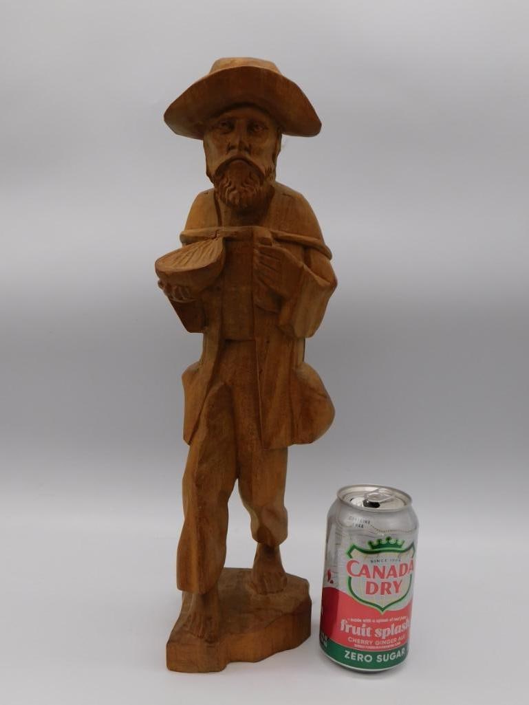 Hand Carved Wood Figurine of Bearded Traveler: A hand-carved wooden figurine of a bearded man in a hat carrying a bowl and satchel, on a natural wood base. Approximately 13 inches tall.
