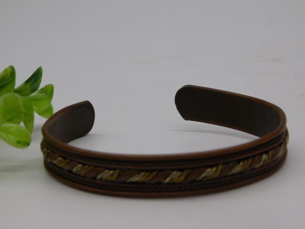 Copper and Brass Twisted Wire Cuff Bracelet: Vintage cuff-style bracelet with copper band featuring a twisted copper, brass, and silver-tone tri-color rope inlay design.