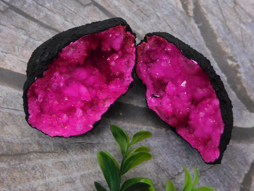 Magenta Crystal Geode Halves: A pair of matching geode halves, 218 grams total, with dark rough exteriors opening to vivid pink/magenta crystal-filled interiors.
