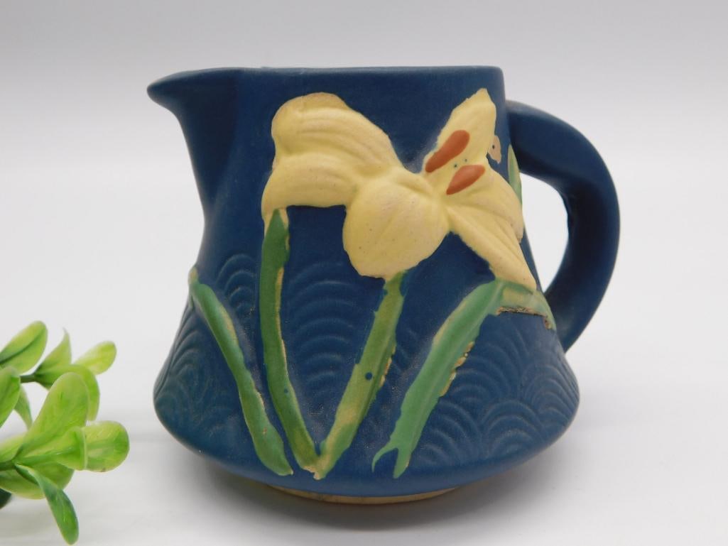 Roseville Pottery Iris Pattern Pitcher: A cobalt blue Roseville pottery creamer/pitcher decorated with a raised yellow iris flower and green leaves, marked Roseville 7-C on the base.