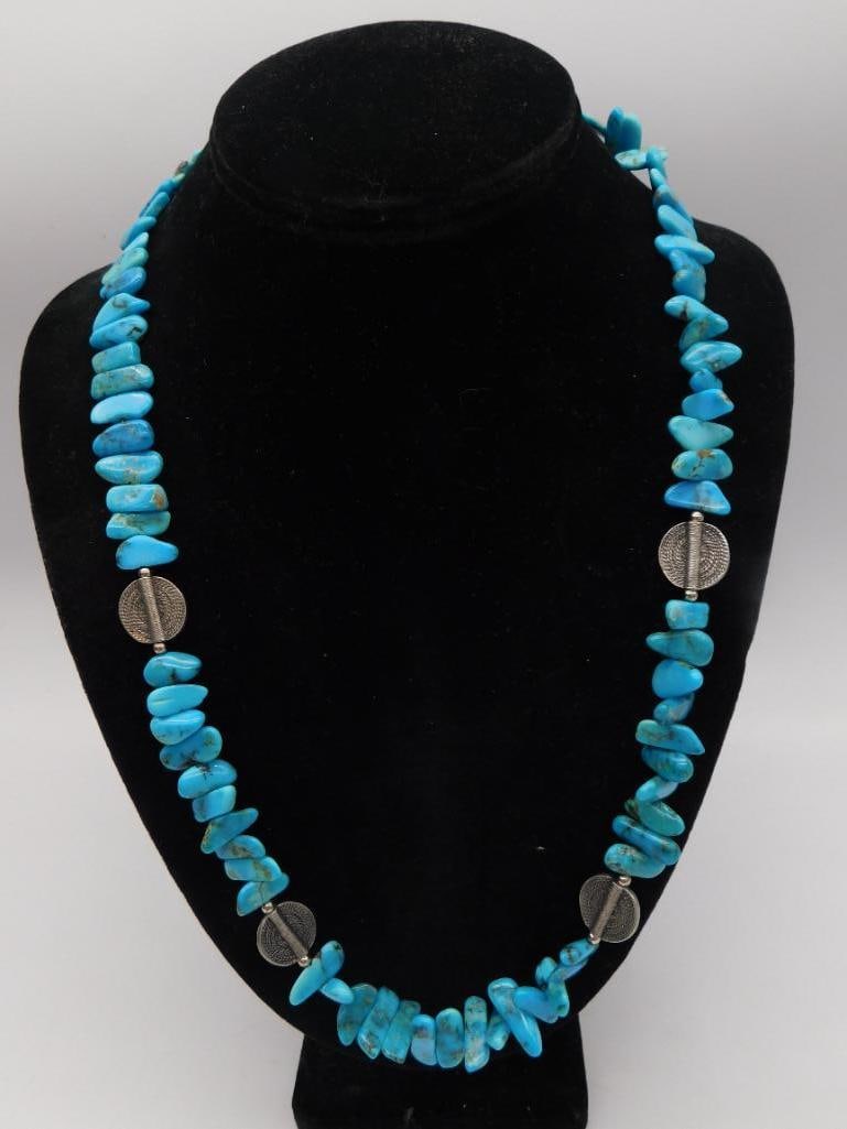 Turquoise Chip Necklace with Sterling Silver Bead Accents: Single strand necklace of natural turquoise nugget chip beads in bright blue with brown matrix, spaced with four engraved sterling silver disc beads. No clasp, continuous strand. Approximately 22-24