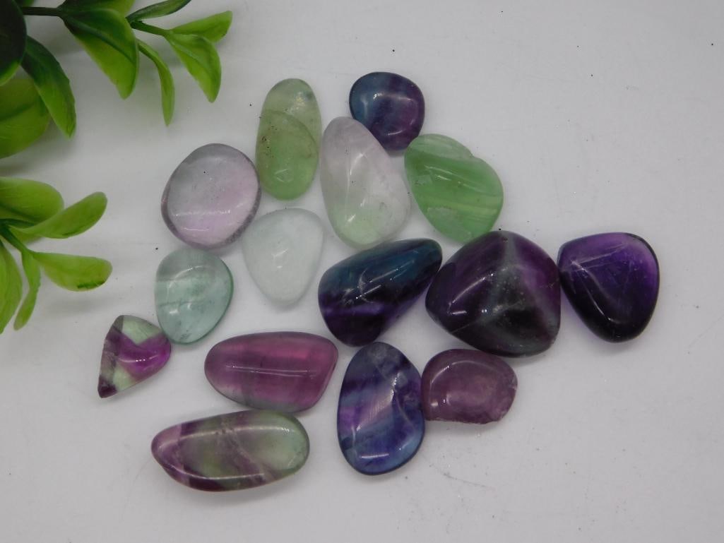 Rock Specimen Tumbled Fluorite Stone Lot: Lot of polished tumbled fluorite stones in assorted colors including purple, green, blue, and clear banded varieties. Weighs approximately 48 grams.