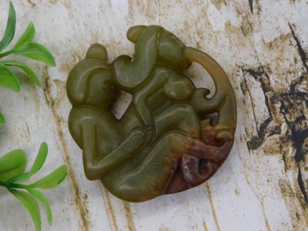 Carved Jade Archaistic Figural Pendant: Carved green and russet jade pendant depicting stylized figures in an archaic Chinese decorative motif with pierced scrollwork border.