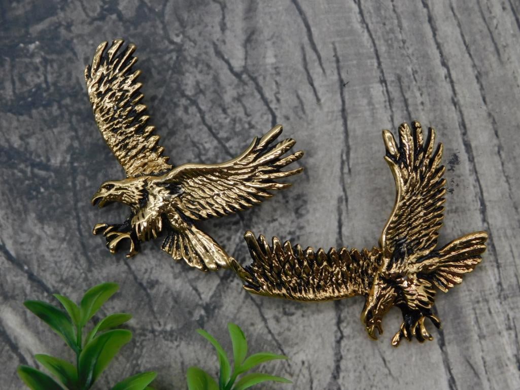 Pair of Gold-Tone Flying Eagle Brooch Pins: Two matching gold-tone metal brooch pins depicting eagles in flight with detailed feather work.