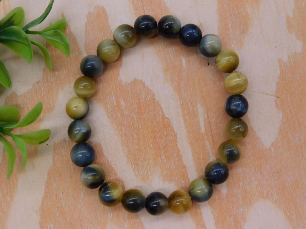 Tiger's Eye Beaded Stretch Bracelet: Stretch bracelet of round polished tiger's eye beads in gold, blue, and brown chatoyant tones.