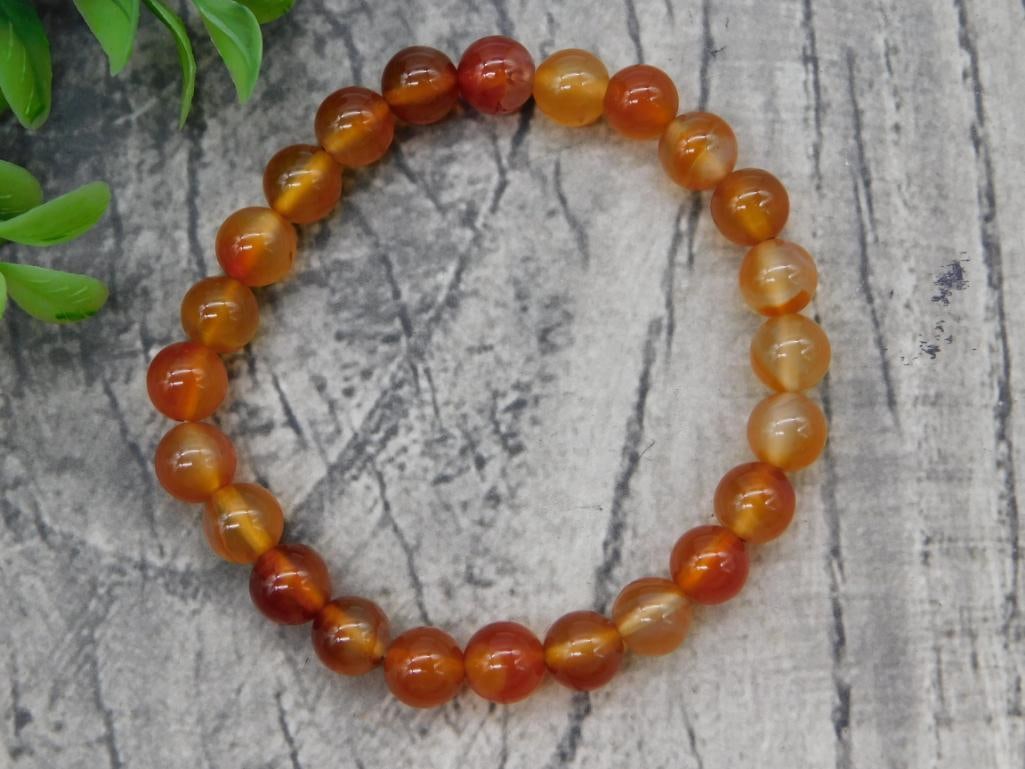 Carnelian Bead Stretch Bracelet: Round bead carnelian gemstone stretch bracelet in orange/red hues.