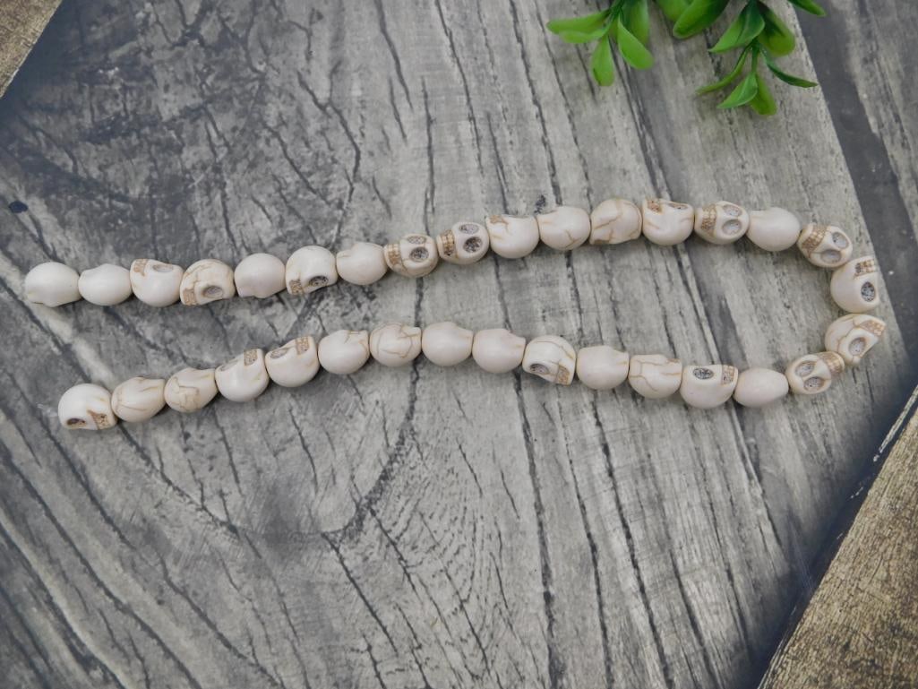 Carved Skull Bead Necklace: Long strand necklace of carved bone/howlite skull beads.