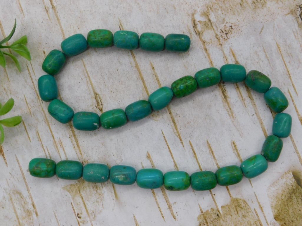 Turquoise-Color Barrel Bead Necklace: Long strand necklace of teal green barrel-shaped magnesite/howlite beads.