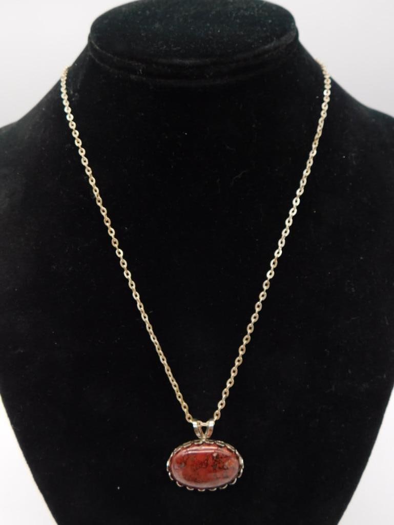 Jasper Pendant Necklace: Silver-tone chain necklace with oval red jasper cabochon pendant in scalloped bezel setting.