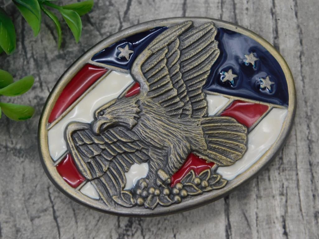 Eagle Patriotic Belt Buckle: Oval brass-tone belt buckle featuring a raised bald eagle over an American flag design with red, white, and blue enamel accents.