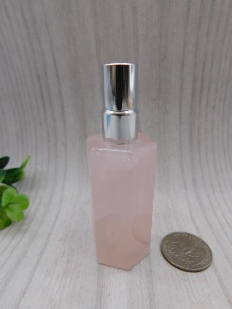 Carved Rose Quartz Perfume Bottle: Faceted carved rose quartz perfume bottle with silver-tone spray cap.